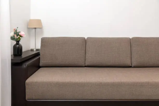 living room interior with brown fabric sofa, wall shelf and decors