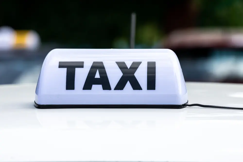 White,Taxi,Sign,On,Top,Of,Car